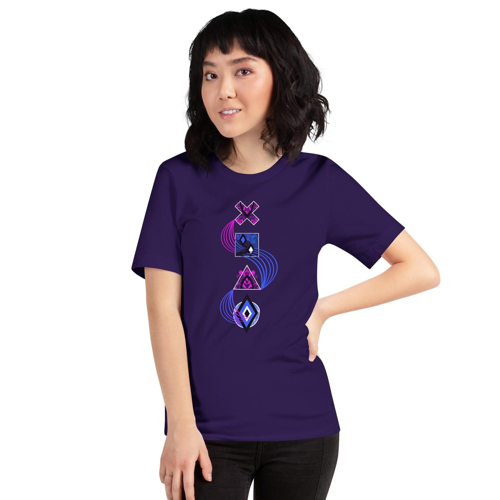 Team purple unisex PlayStation controller symbols t-shirt with neon blue and pink swirl linking stylized cross (×), square (□), triangle (△), and circle (○) icons. Standing in front of a brick wall.